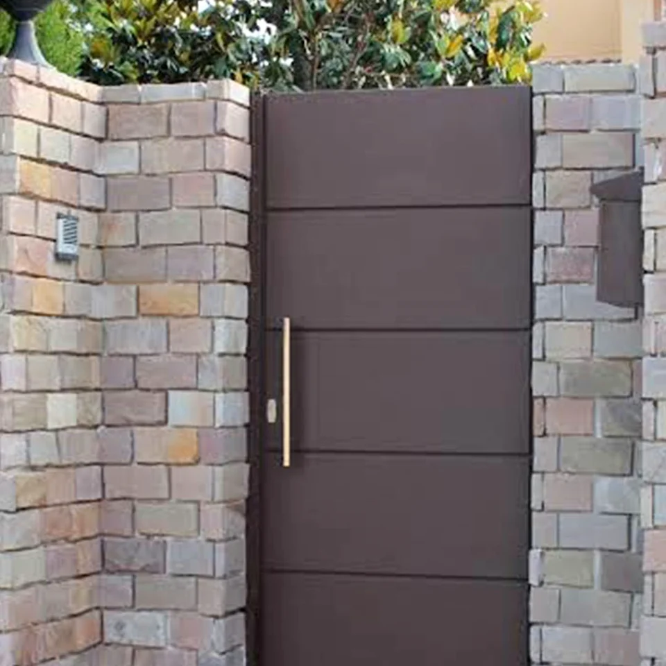 Puerta peatonal marrón de paneles horizontales entre muros de piedra